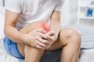 Hva skjer når kneskålen går ut av ledd (patellaluksasjon)? 2 close up man holding sore knee 23 2147948562 300x200 1